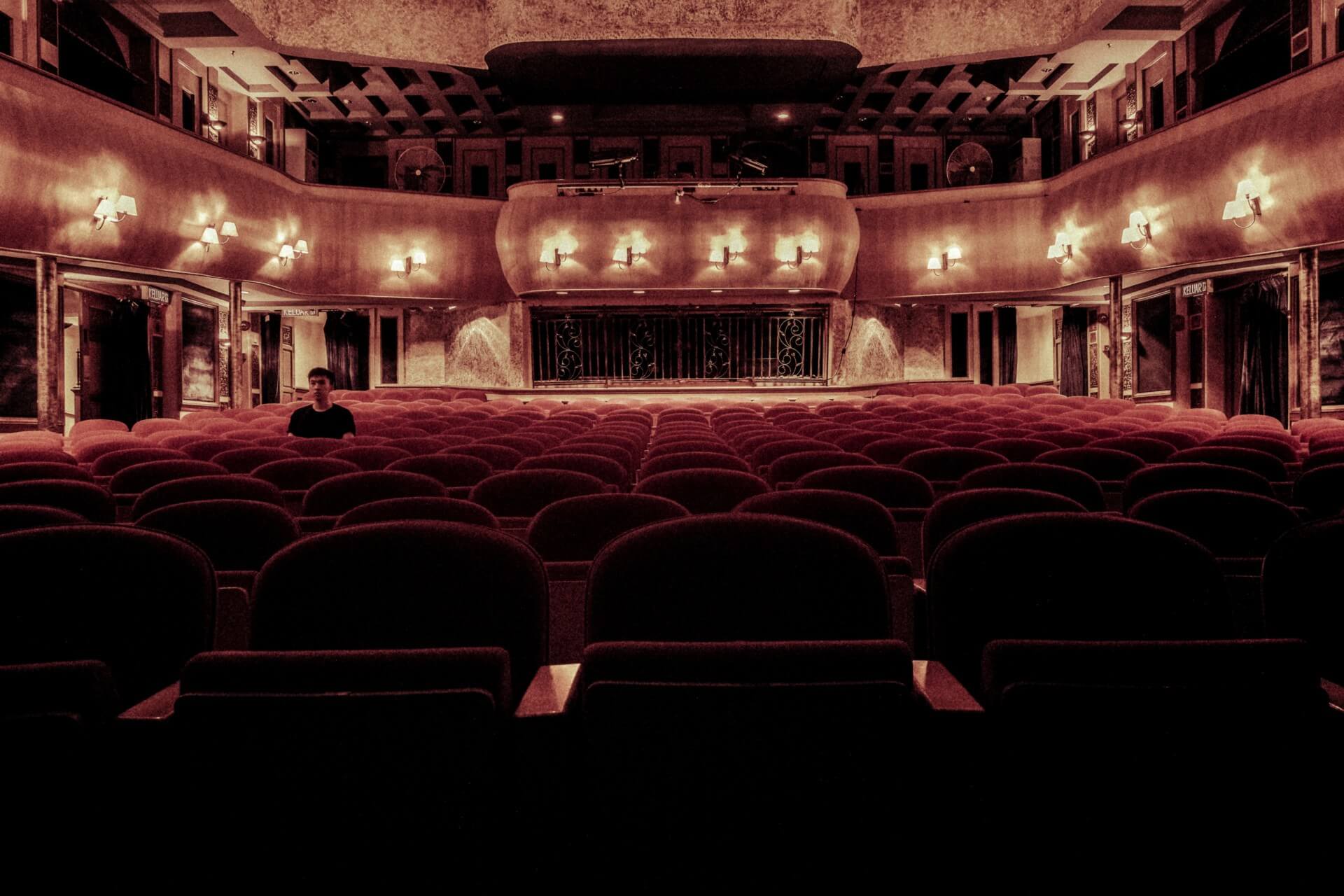 one audience member in a large empty theatre