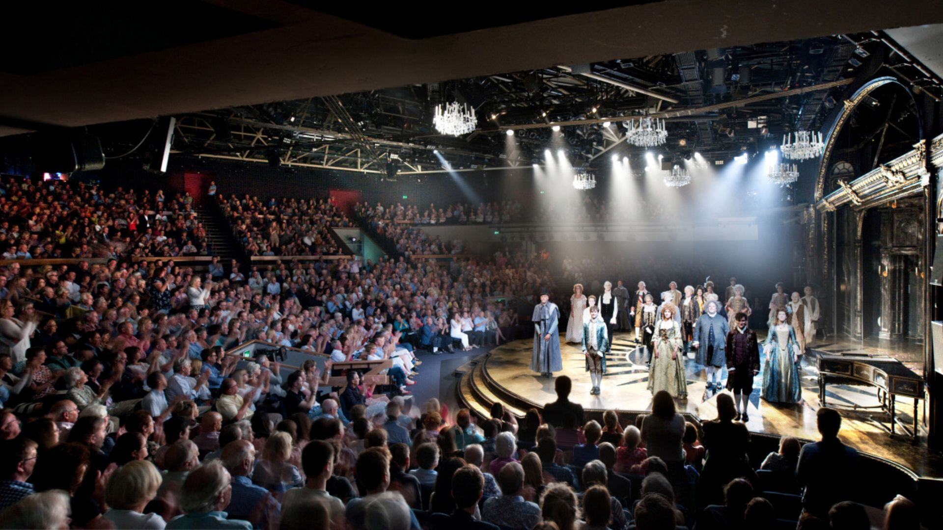 Full Chichester Festival Theatre auditorium with standing ovation towards cast on stage